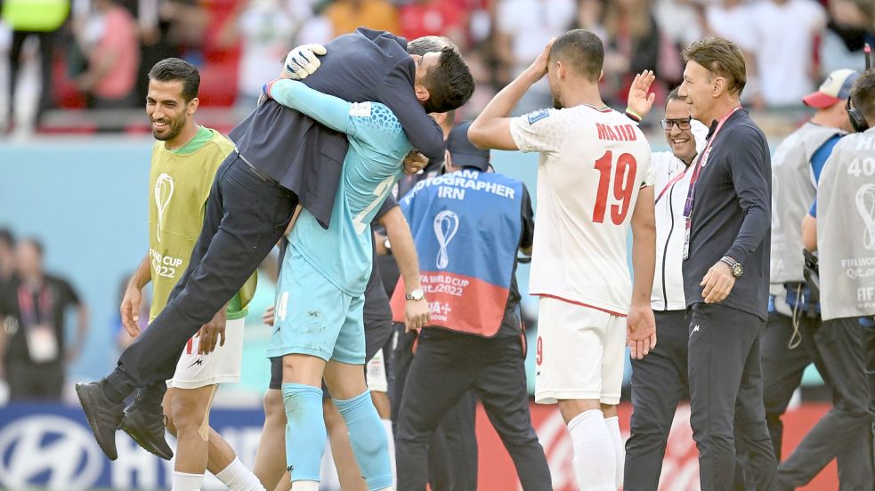Irans Spieler feiern nach dem Sieg gegen Wales ihren Trainer Carlos Queiroz. Foto: Federico Gambarini/dpa