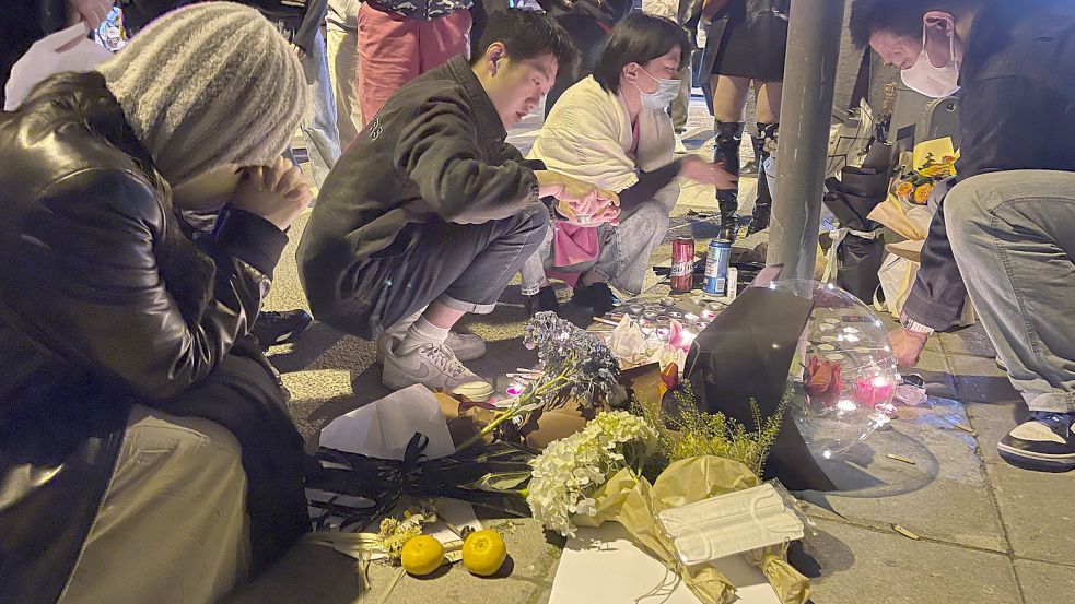 China am vergangenen Wochenende: Zahlreiche Anwohner legen Blumen und Kerzen nieder für die Opfer eines Brandes in einem Wohnhaus in der Stadt Urumqi. Der Brand im Nordwesten des Landes war Auslöser für Proteste in mehreren Metropolen. Foto: Uncredited/CHINATOPIX/AP/dpa