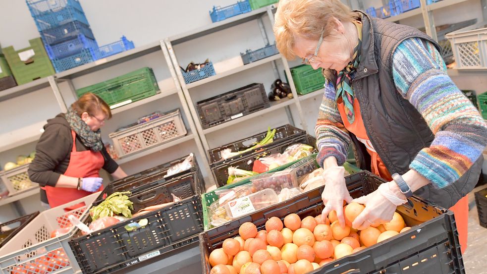 Vielbeschäftigt: Die ehrenamtlichen Helferinnen Susanne Peters (links) und Hannelore Schug von der Auricher Tafel packen Lebensmittel-Kisten für die Kunden. Foto: Ortgies