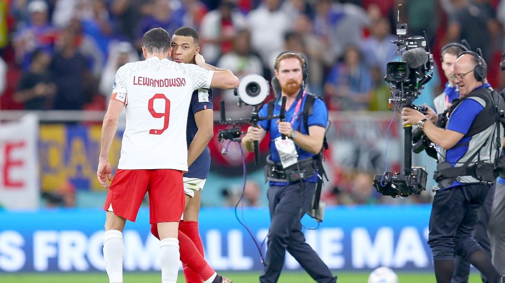 Nach dem Spiel umarmt Robert Lewandowski (l) Frankreichs Doppeltorschützen Kylian Mbappé. Foto: Tom Weller/dpa