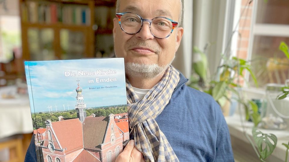 Christian Züchner hält sein Buch über die Neue Kirche Emden in der Hand. Viele Fotos und kurze Texte, so ist der Bildband aufgebaut. Foto: Privat