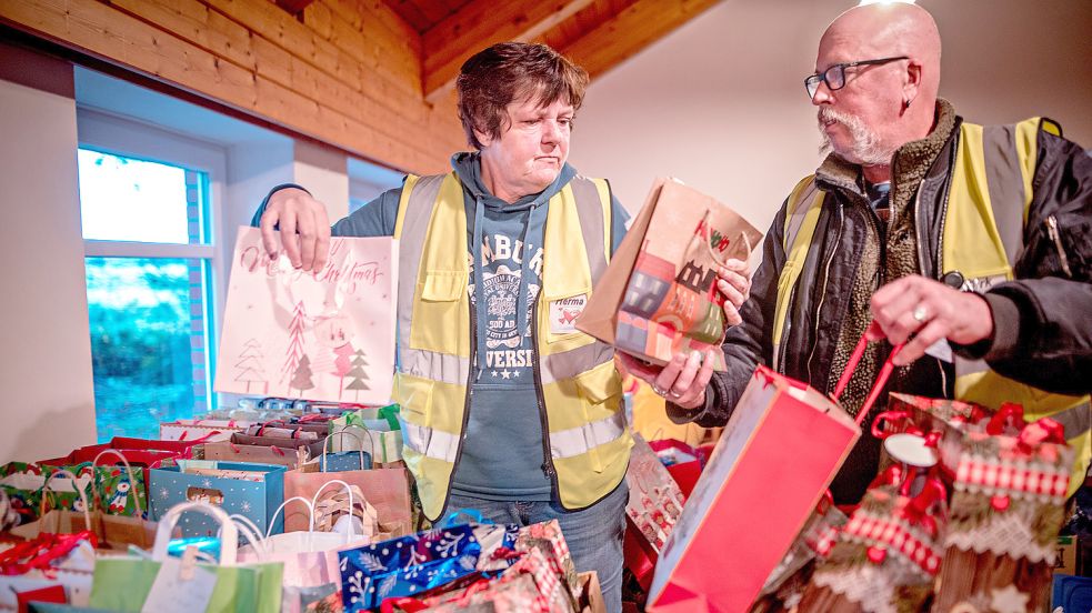 Herma Schoon und Dirk Sondermann inmitten von Geschenktüten, die sie zum Fest an Bedürftige verteilen möchten. Foto: Cordsen