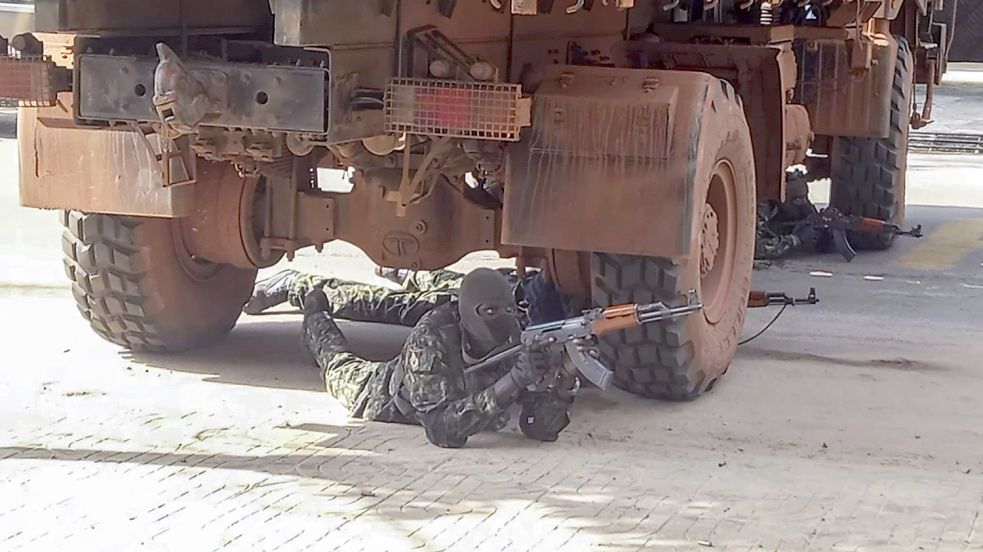 Diese Aufnahme aus Conakry, der Geburtsstadt von Abdoul Rahimi Diallo in Guinea, hat die Deutsche Presse-Agentur am 6. September 2021 verbreitet: „Dieses Videostandbild zeigt einen nicht identifizierten Soldaten unter einem Lastwagen in der Nähe des Büros des Präsidenten in Stellung. Die neue Militärführung Guineas hat nach dem Sturz von Präsident Alpha Conde versucht, ihre Macht zu festigen. Sie warnte lokale Beamte, dass die Weigerung, an einem für Montag einberufenen Treffen teilzunehmen, als Rebellion gegen die Junta gewertet würde.“ [Textbaustein: Bildhinweis] Foto: Uncredited/AP/dpa