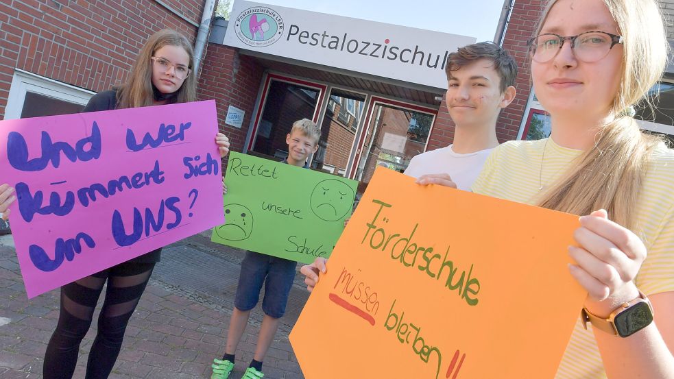 Lea-Sophie (von links), Luca, Sean-Ray und Ina zeigen, was sie von einer Schließung der Pestalozzischule hielten. Foto: Ortgies