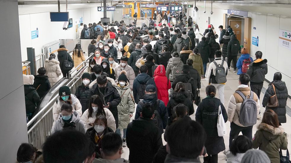 Zahlreiche Fahrgäste gehen während der morgendlichen Hauptverkehrszeit durch die U-Bahn-Station Hujialou in Peking. Die Beschränkungen in China sind verschwunden, die Corona-Infektionszahlen steigen. Foto: Ju Huanzong/XinHua/DPA
