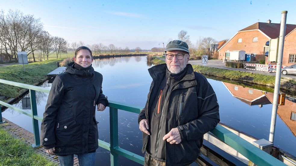Julia Szymanski und Klaus Möhlmann aus dem Vorstand des Heimatverein mögen den Blick von der Klappbrücke auf den Ems-Jade-Kanal und das Dorf. Foto: Ortgies
