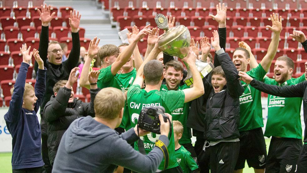 Nach dem Leeraner Kreismeistertitel gewann Fußball-Landesligist GW Firrel nun auch den Aurich-Cup. Als die Mannschaft den Pokal bekam, hatten sich die Tribünen schon geleert. Es war weit nach 22 Uhr. Foto: Doden/Emden