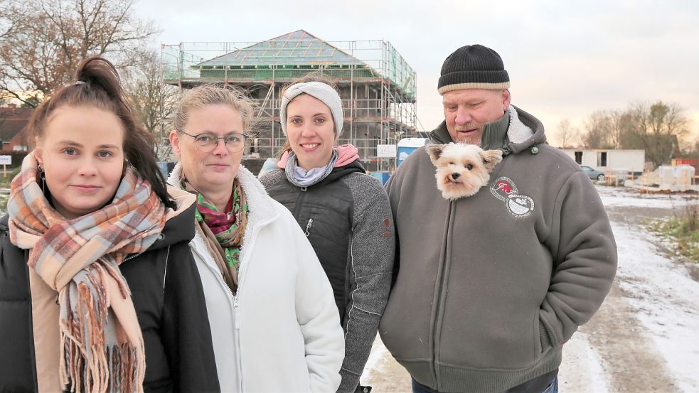 Warten auf das Internet: Anna Großhennig (von links), Christel Petzl, Jana Haarsche und Ralf Petzl mit Sir Wilhelm unter der Jacke im neuen Baugebiet „Theeneschlootpad“. Foto: Böning