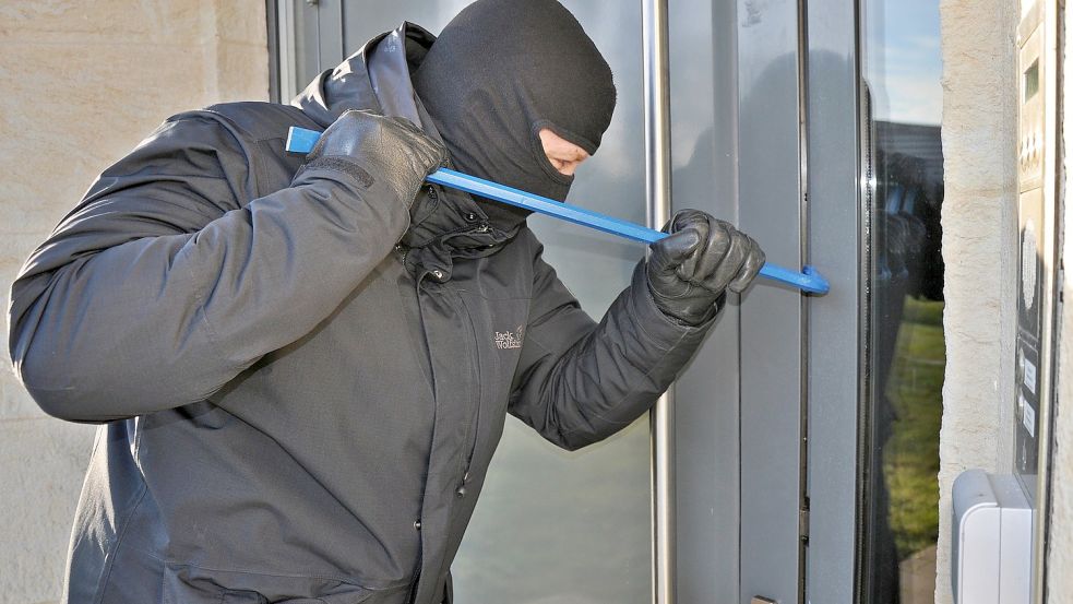 Ein Einbrecher macht sich an einer Haustür zu schaffen. Wenn man mitbekommt, dass jemand in der eigenen Wohnung einbricht, sollte man sich verstecken und die Polizei anrufen. Symbolfoto: Pixabay