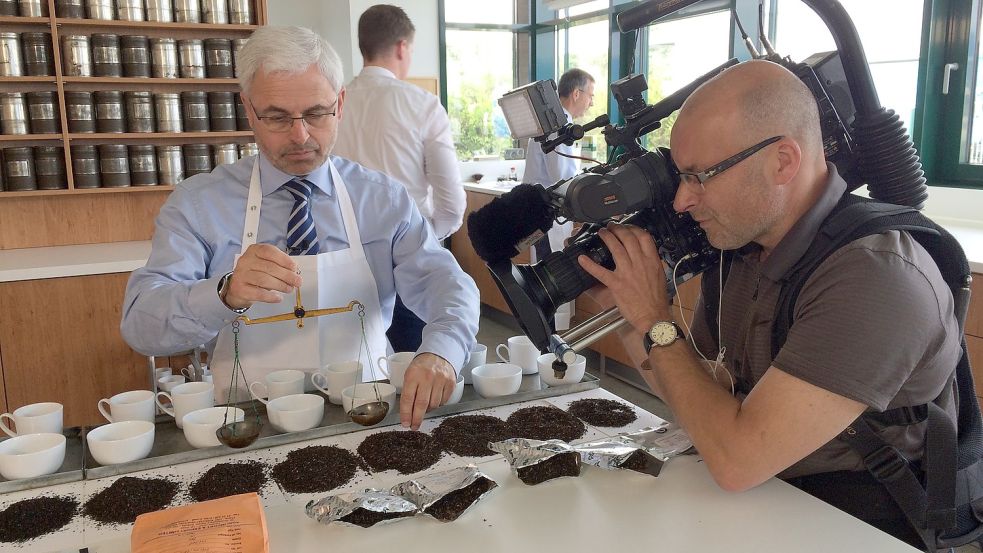 Ralf Töpfer im Fokus der Kamera: Mit einer Waage werden immer genau 2,8 Gramm Tee für eine Probe abgewogen. Foto: Ahrens
