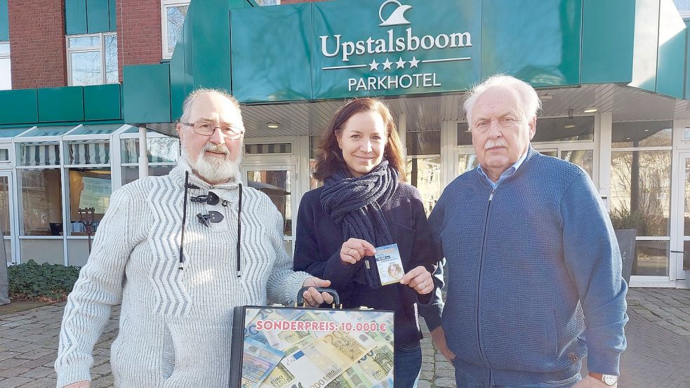 Uwe Hellmann (links) und Wilhelm Eilers (rechts) überreichten den symbolischen Geldkoffer mit 10.000 Euro an Anja Weiler von der Upstalsboom-Gruppe. Foto: Hanssen