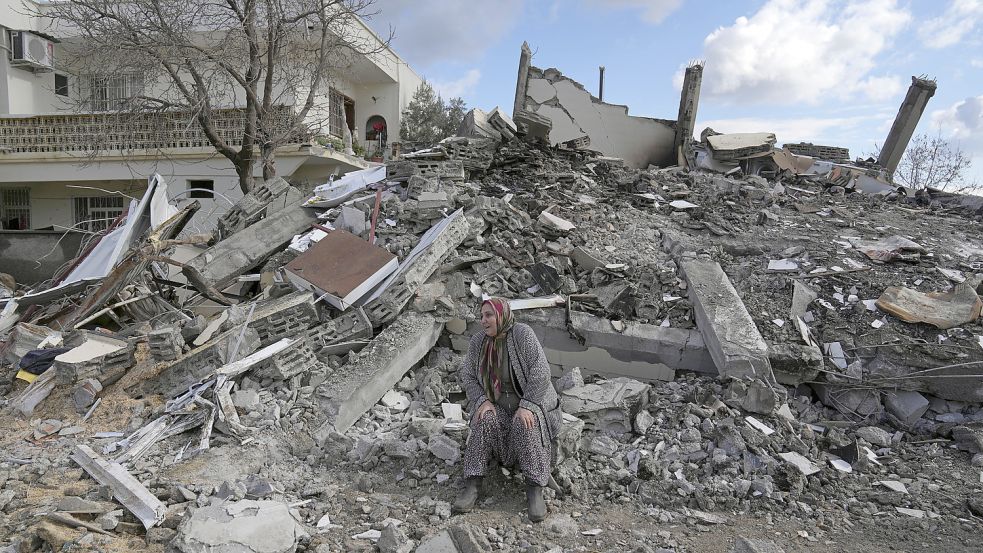 Eine Frau sitzt am Dienstag im türkischen Osmaniye auf Trümmern. Mehr als 13 Millionen Menschen in der Türkei sind nach Einschätzung der Regierung von der Erdbebenkatastrophe betroffen. Foto: Hamra/AP/DPA