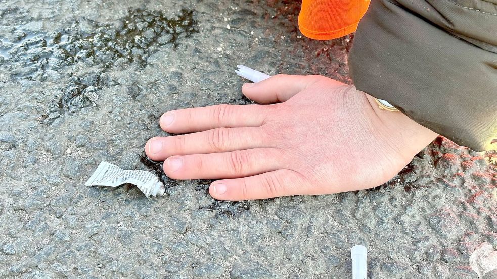 Eine Klimaaktivistin hat sich mit der Hand auf einer Hauptverkehrsstraße festgeklebt. Foto: Peter Zschunke/dpa-Zentralbild/dpa