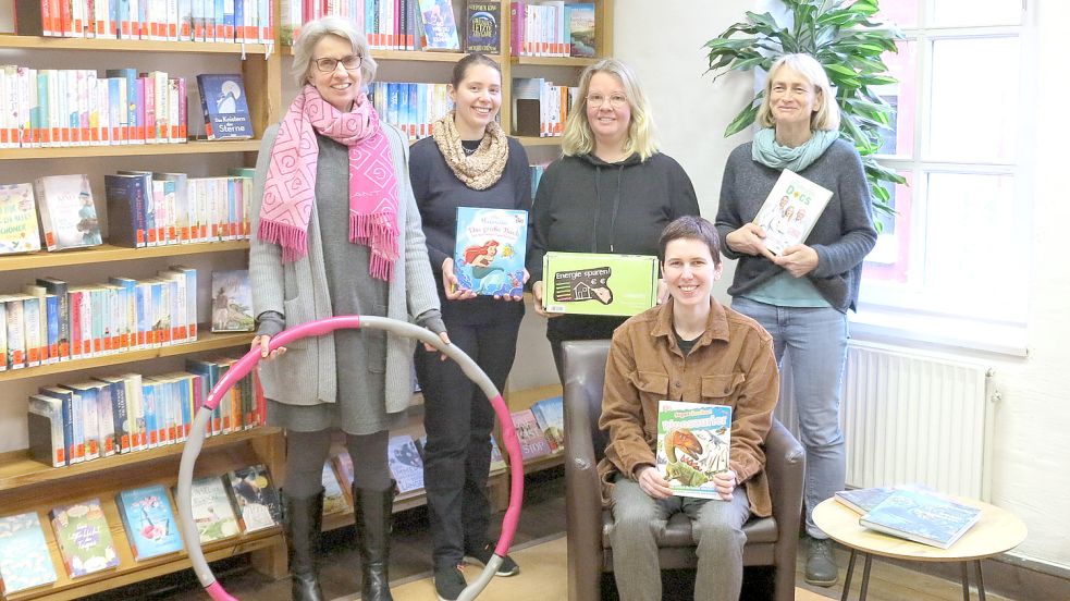 Das Norder Bibliotheks-Team (von links): Leiterin Anke Czepul, Stefanie Häwel, Maike Ennen, Hedda Carstens und sitzend die Auszubildende Laura Grabowski. Auf dem Foto fehlt Vera Wienkämper. In den Händen halten die Mitarbeiterinnen die „Bestleiher“ des vergangenen Jahres, darunter einen Hula-Hoop-Reifen, ein Strommessgerät und die „Ernährungsdocs“. Foto: privat