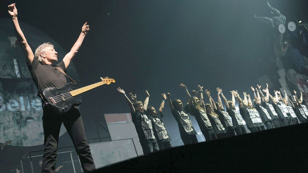 Der britische Sänger, Bassist und Mitbegründer der Band Pink Floyd, Roger Waters (links), steht 2011 in Berlin auf der Bühne zwischen den Tänzern. Damals hatte er die Show „The Wall“ zum ersten Mal seit 1990 wieder in kompletter Länge gezeigt. Foto: Pedersen/DPA