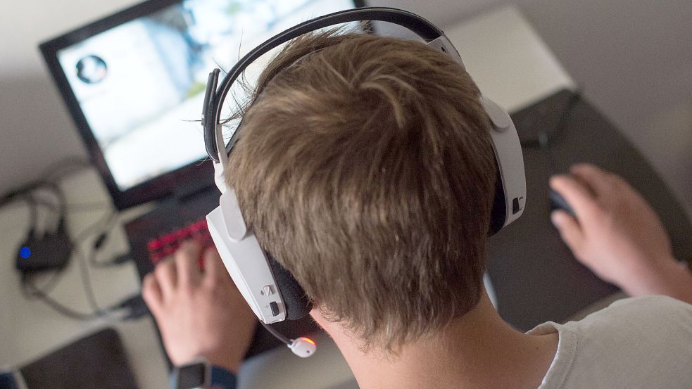 Ein Jugendlicher sitzt mit einem Headset vor einem Laptop und spielt ein Online-Computerspiel. Foto: Mirgeler/DPA/Archiv