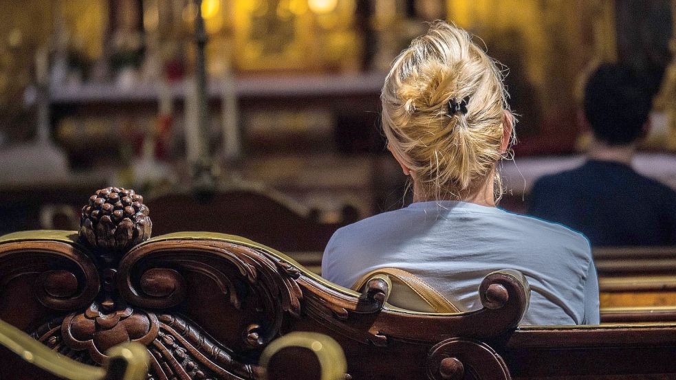 Eine Frau sitzt in der Kirchenbank. Symbolfoto: Pixabay