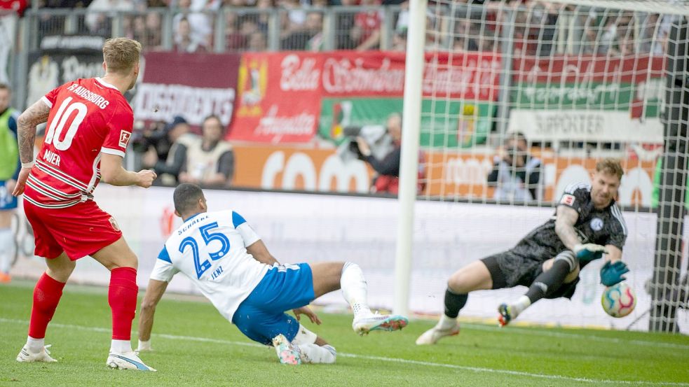Schalkes Torwart Ralf Fährmann (r) und Moritz Jenz können das Tor von Augsburgs Arne Maier (l) nicht verhindern. Foto: Stefan Puchner/dpa