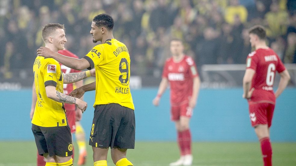 Dortmunds Sebastien Haller (r) gratuliert Marco Reus zu seinen beiden Treffern. Foto: Bernd Thissen/dpa