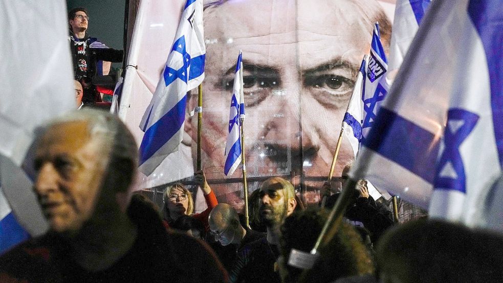 Demonstranten nehmen mit israelischen Fahnen an einem Protest gegen die Pläne der israelischen Regierung teil. Foto: Ohad Zwigenberg/AP/dpa