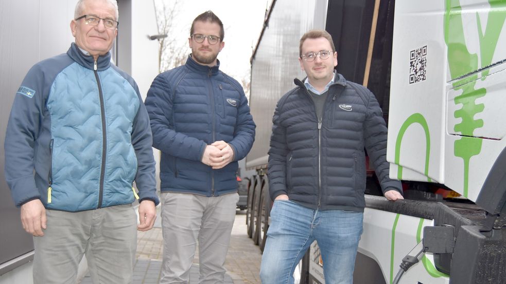 Das Ladekabel ist eingestöpselt: Sebahittin Aktas (von links), Arthur Kasperczyk und Niklas Wiese sind begeistert von der elektrifizierten Zugmaschine. Foto: Prins