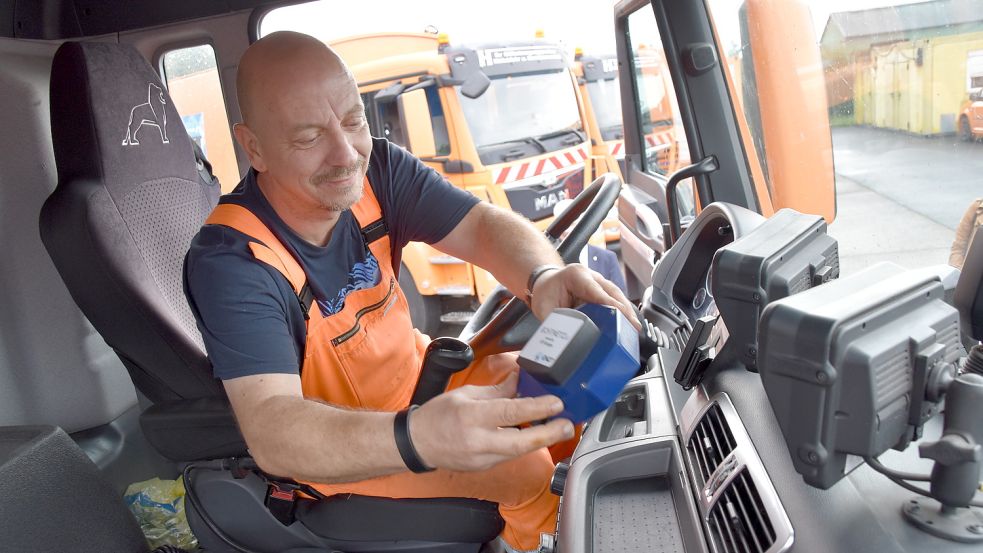 Auch im Landkreis Leer werden Messgeräte in Müllwagen installiert. Fahrer Kai Möller legt das Gerät auf dem Armaturenbrett ab. Fotos: Archiv/Wehry