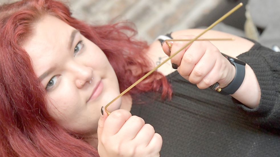 Mit der Wünschelrute nimmt Antonia Kontakt zu den Seelen auf, die aus ihrer Sicht an den Puppen anhaften. Foto: Ortgies