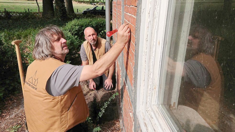 Sven Rathjen und Horst Ubben vom Monumentendienst bei der Arbeit: Hier inspizieren die Fassade eines historischen Gebäudes. Foto: Ahrends