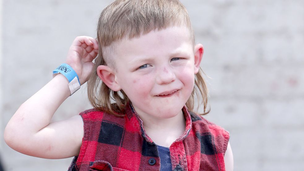 Selbst die Kleinsten haben mit Vokuhila die Haare schön. Das Foto zeigt einen Jungen in Australien, wo bei dem alljährlichen Mulletfest in Kurri Kurri der Vokuhila zelebriert wird. Foto: dpa/Pateman