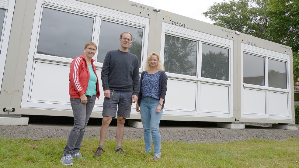 Statt dieses Containers soll der Kindergarten Jheringsfehn ab diesem Jahr neue Räume in einer Erweiterung bekommen. Das Bild zeigt Kindergartenleiter Benjamin Schüdde und seine Kolleginnen Elke Schüdde (links) und Christel Theermann. Foto: Lüppen/Archiv