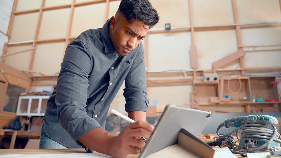 Arbeit zwischen Werkbank und Tablet gehört für viele Handwerker in Ostfriesland dazu. Foto: StratfordProductions/stock.adobe