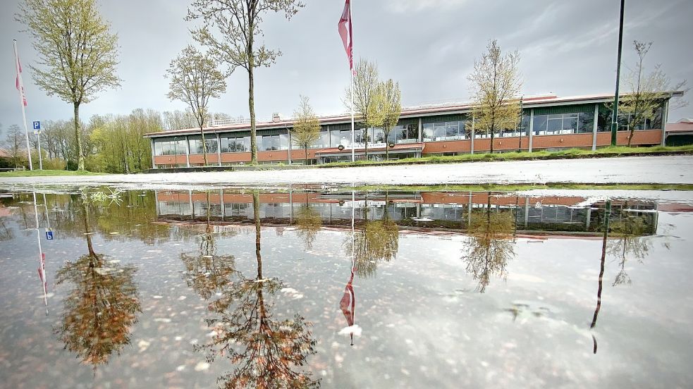 Die große Halle des RTC in Timmel spiegelt sich in einer Pfütze. In den kommenden Wochen wird sich herauskristallisieren, wie es mit der Anlage weitergeht. Foto: Cordsen
