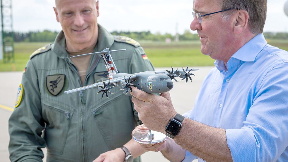 Boris Pistorius (r., SPD), Bundesverteidigungsminister, hält bei seinem Antrittsbesuch bei der Luftwaffe neben dem Luftwaffen-Inspekteur Ingo Gerhartz auf dem Fliegerhorst Laage das Modell des Transportflugzeugs A400M. Foto: Jens Büttner