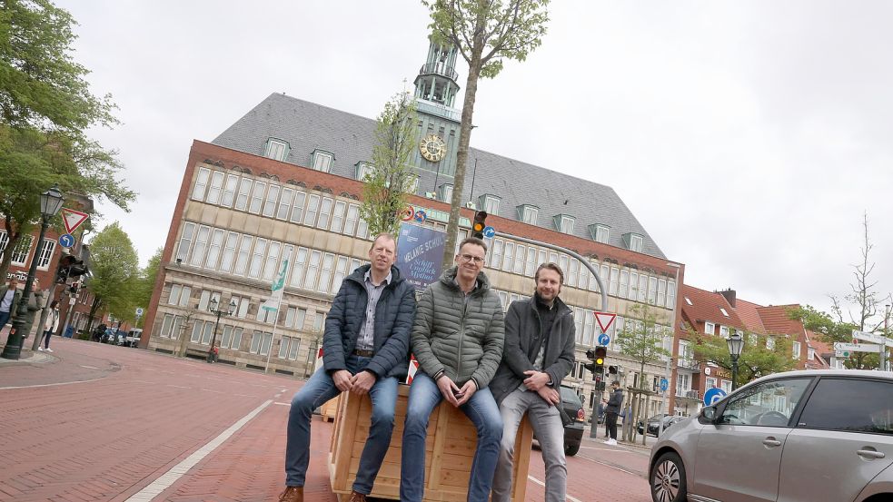 Wolfgang Fecht (Bau- und Entsorguingsbetrieb Stadt Emden, von links), Hinrich Post (Fachdienst Verkehr) und Stadtplaner David Malzahn machen es sich fürs Foto auf einem der neuen Baumkübel in Emden bequem. Foto: Hock