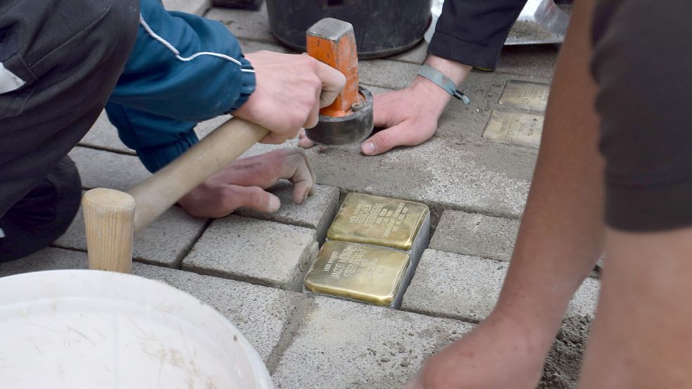 Mit dem Gummihammer arbeiteten die Schüler die Stolpersteine in das Pflaster ein. Foto: Hoppe