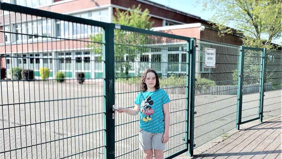 Der Schüler Jonathan steht am Eingangszaum zur Kooperativen Gesamtschule (KGS). Im Hintergrund ist der Teil der Schule, der saniert werden muss. Foto: Hochmann