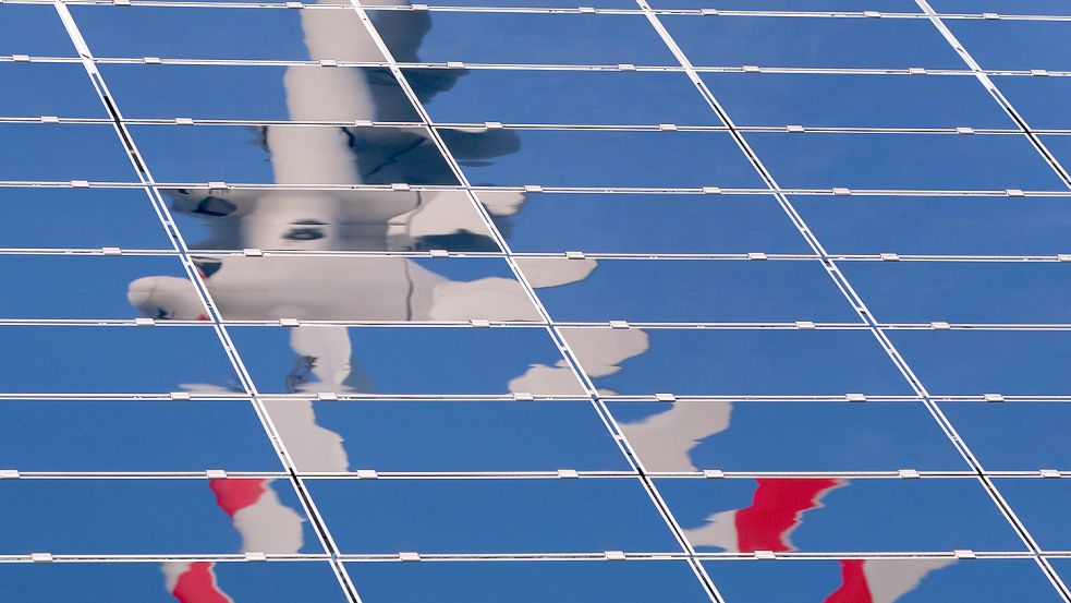 Ein Windrad spiegelt sich in einer Solaranlage. Im Handeln der Bundesregierung spiegelt sich aber nur bedingt deren klimapolitische Ziele wider, kritisiert der Bundesrechnungshof. Foto: Hildenbrand/dpa