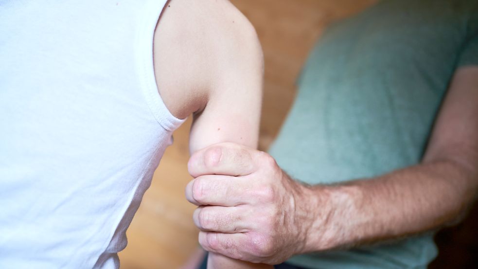 Ein Mann hält in einer gestellten Szene ein Kind fest am Arm. Die Zahlen kindlicher Gewaltopfer sind weiterhin hoch. Foto: Riedl/DPA