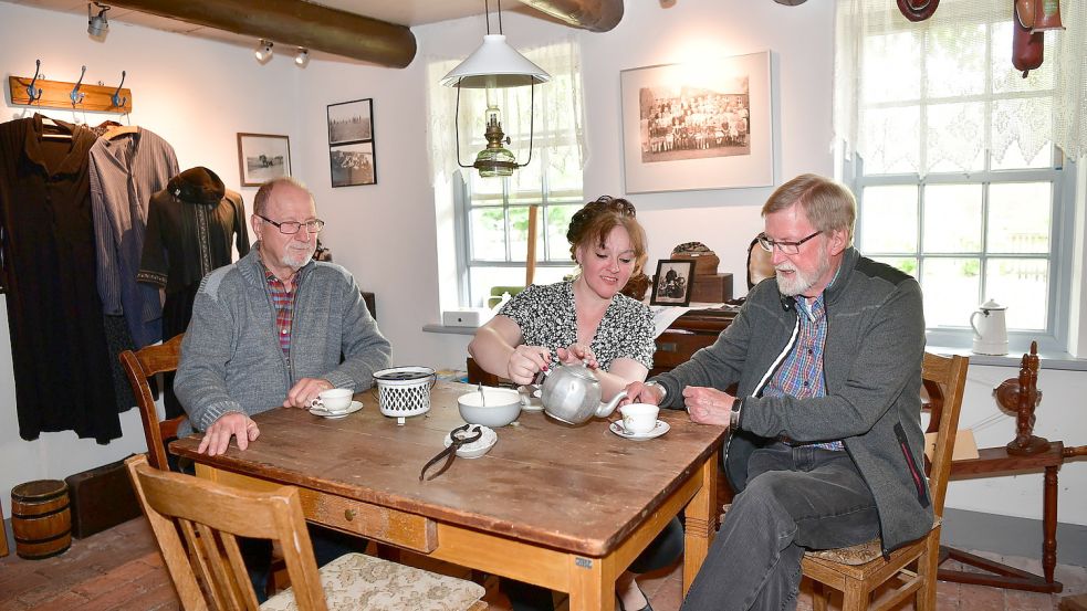 In der guten Stube des Landarbeitermuseums ist der Tisch schon für die Teetied von Erwin Wenzel (von links), Gitta Nörtker und Johannes W. Saathoff gedeckt. Foto: Wagenaar