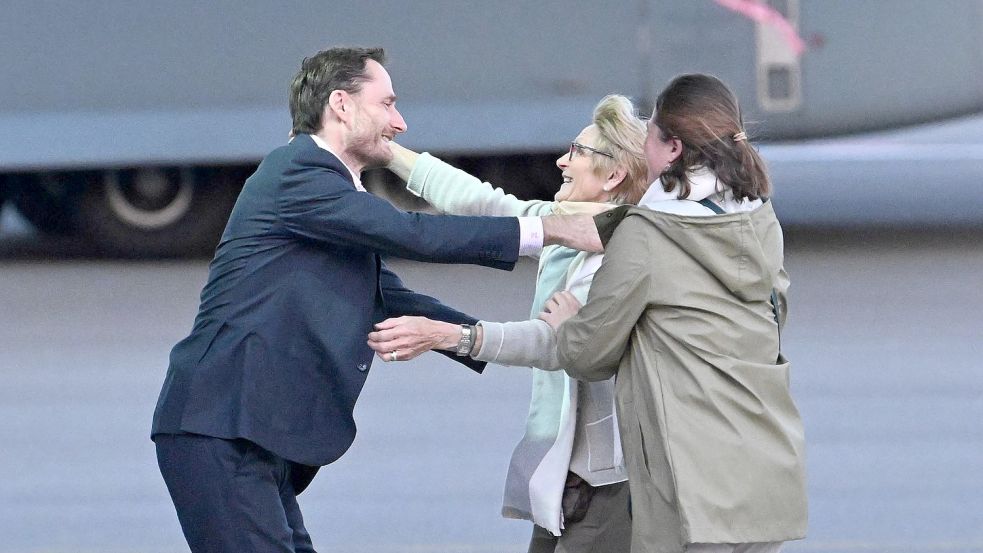 Olivier Vandecasteele (l) trifft seine Familie bei der Ankunft auf dem Militärflughafen Melsbroek. Foto: Pool Didier Lebrun/Belga/dpa