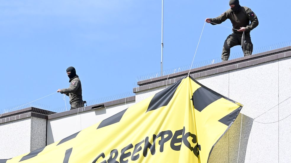 Mitglieder einer Einheit des SEK der Polizei stehen auf dem Dach des niedersächsischen Landtags und entfernen ein Transparent von Greenpeace gegen eine geplante Gasbohrung vor Borkum. Die Protestaktion der Umweltschutzorganisation in Hannover stieß auf deutliche Kritik. Foto: Julian Stratenschulte/dpa