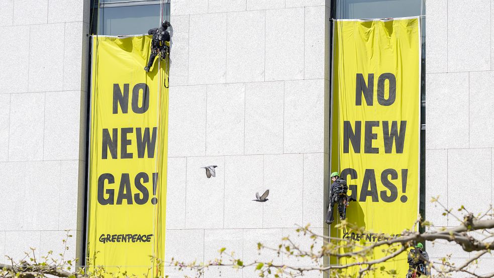 Greenpeace-Aktivisten (rechts) demonstrierten Anfang Mai am niedersächsischen Landtag mit Transparenten mit der Aufschrift „No new gas“ („Kein neues Gas“), während Einsatzkräfte der Polizei (links) damit beginnen, diese zu entfernen. Nun erhält die Umweltschutzorganisation eine Rechnung vom Land für den entstandenen Schaden am Dach. Foto: Julian Stratenschulte/dpa