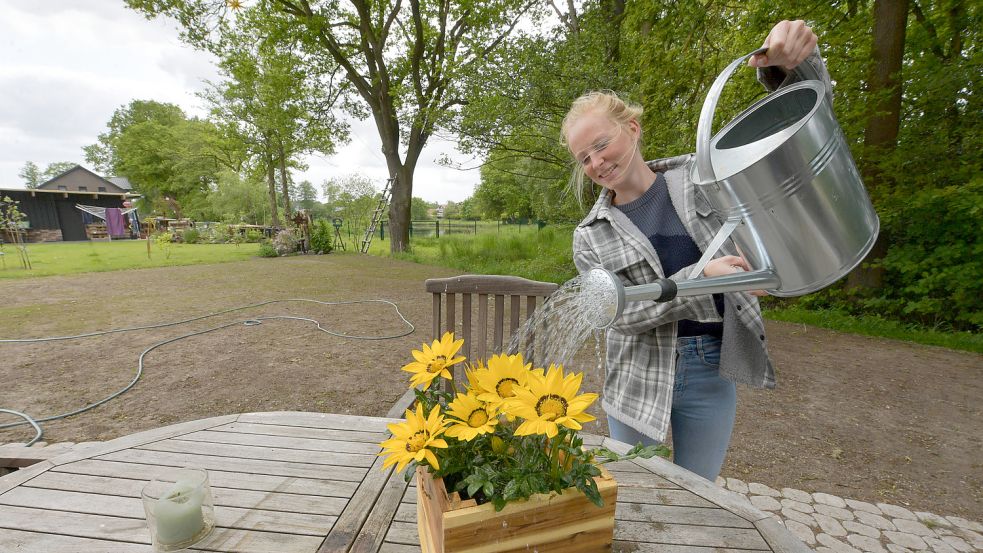 Blumen gibt es momentan erst im Topf. Lisa-Marie Fricke hat aber schon Ideen, welche Pflanzen sie setzen möchte. Im Hintergrund ist die Rasenfläche zu sehen, auf der sich das erste Grün zeigt. Foto: Ortgies