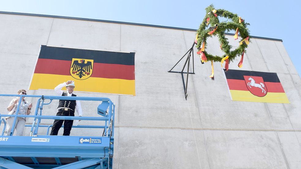 Polier Hans-Otto Büürma erhob das Glas und weihte die neue Luftfahrzeughalle. Fotos: Hochmann