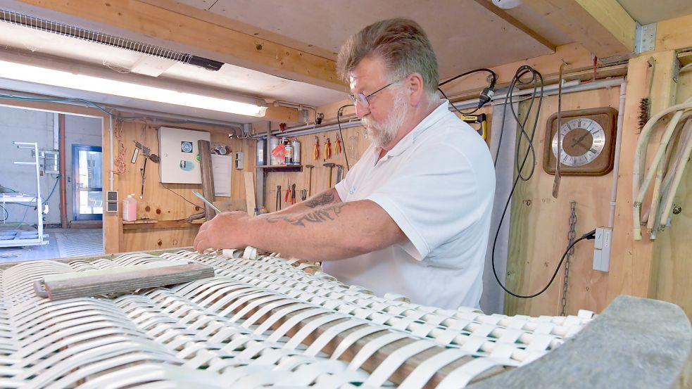 In seiner Werkstatt in einer Lagerhalle für Strandkörbe geht Uwe von der Pütten seiner Arbeit nach. Foto: Ortgies