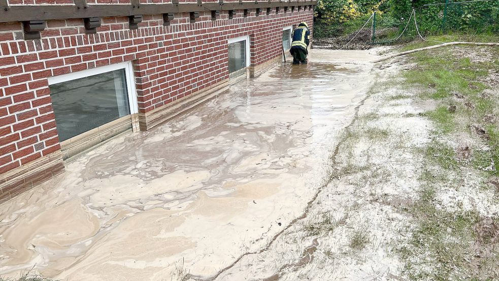 Das wird teuer: Ein Feuerwehrmann pumpt Regenwasser aus der Grube vor einem Wohnhaus. Die Aufnahme stammt vom 22. Mai dieses Jahres aus Georgsmarienhütte. Foto: Kipp/Nord-West-Media/DPA