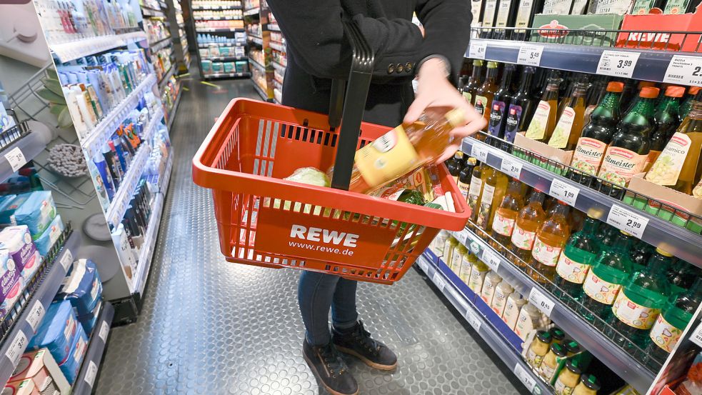 Eine Frau kauft in einem Rewe-Markt ein. In Ostfriesland gibt es bislang nur einen - in Emden. Außerdem gibt es drei "Rewe to go"-Standorte in Hesel, Leer und Aurich. Foto: Arne Dedert/dpa
