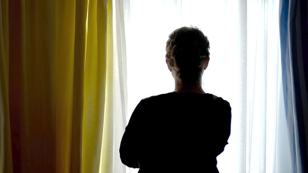 Eine junge Frau steht in einem Zimmer eines Frauenhauses. Foto: Peter Steffen/dpa