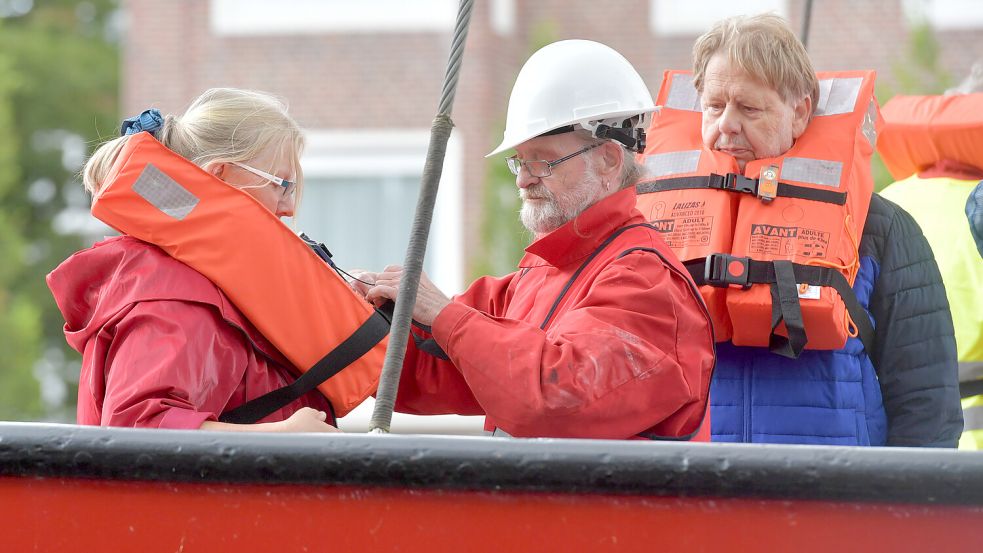 Die Übungsteilnehmer waren in Gruppen eingeteilt: hier die Gruppe Rot. Ein Crewmitglied hilft beim Anlegen der Rettungsweste. Foto: Ortgies