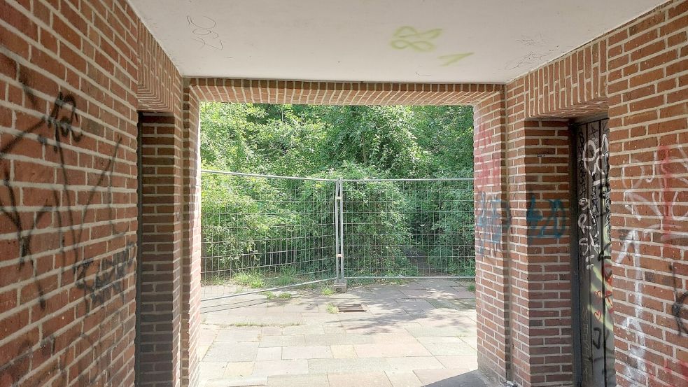 Zuvor konnte man durch den Bogen im Kirchturm noch zum Trampelpfad gelangen. Jetzt steht ein Bauzaun dort. Foto: Hanssen